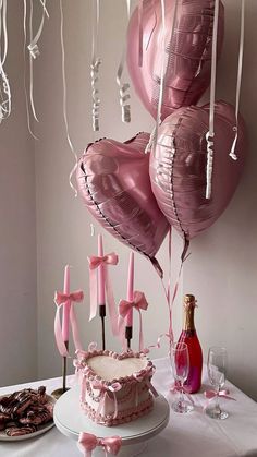 a table topped with a cake and balloons