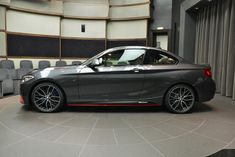 a grey car is parked in front of some chairs