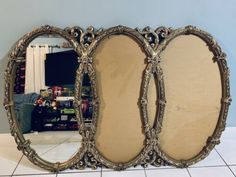 three oval mirrors sitting on top of a tiled floor next to a wall with a mirror in the middle