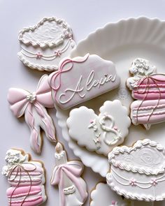 some decorated cookies are on a plate with pink ribbons and bows around the edges that say hello