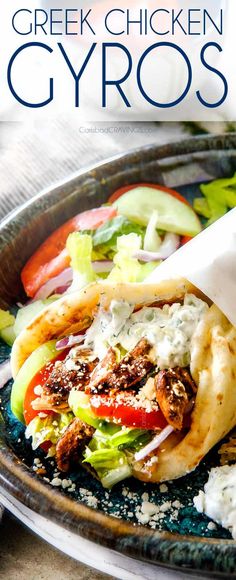 greek chicken gyros with lettuce, tomatoes and onions on a plate