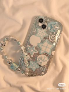 a cell phone case sitting on top of a bed covered in blue and white decorations