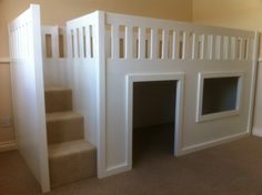 there is a dog house built into the wall next to some stairs in this room