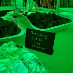 there are many tin foil containers with food in them on the table and one has a sign that says everything tastes like chicken