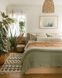 a bedroom with a bed, rug and plants in it