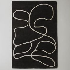 a black rug with white lines in the shape of an abstract figure on top of it