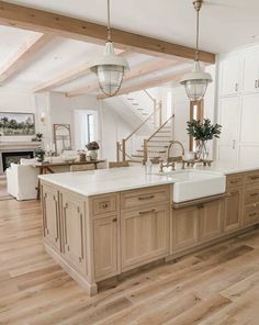 a large kitchen with an island in the middle and stairs to the second floor above it