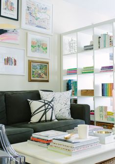 a living room filled with furniture and lots of books on the shelves in front of it