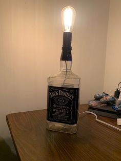 a bottle with a light on top of it sitting on a table next to a pair of shoes