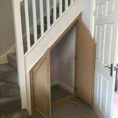 an open dog door in the corner of a staircase leading up to a set of stairs