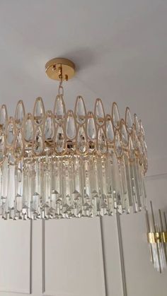 a crystal chandelier hanging from the ceiling in a room with white cupboards