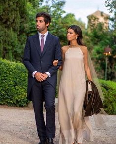 a man in a suit and tie walking next to a woman