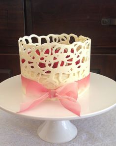 a white cake with pink bows on top