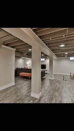 an empty room with wood floors and white walls