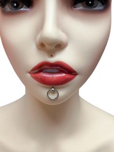 a female mannequin with red lipstick and piercing on it's nose is shown