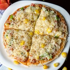 a white plate topped with a pizza covered in cheese and veggie toppings