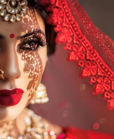 a woman with makeup on her face and red veil