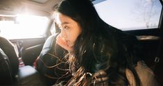 a woman sitting in the back seat of a car