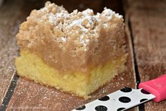 a piece of cake sitting on top of a wooden table next to a spatula