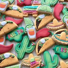 some decorated cookies are on a table with cactuses and other things in the background