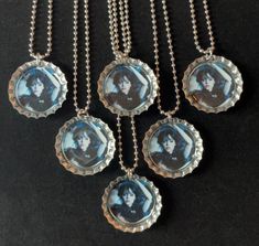 four necklaces with pictures on them hanging from chains