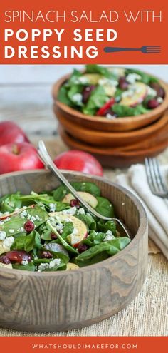 spinach salad with poppy seed dressing in a wooden bowl on top of a table