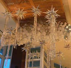 a chandelier hanging from the ceiling filled with balloons and starbursts