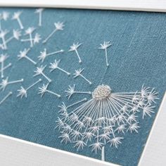 a close up of a dandelion on a blue background in a white frame