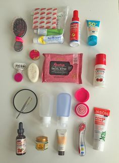 the contents of a personal care kit laid out on a white counter top, including toothbrushes, soaps, and other items