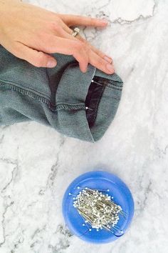 a person's hand is opening the pocket of a pair of jeans with silver flakes in it