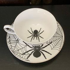 a spider - web bowl and saucer on a black table