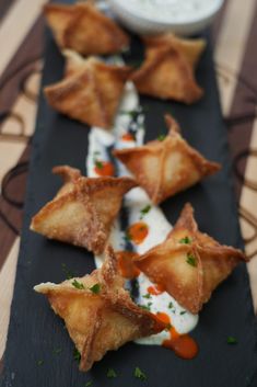 small appetizers are arranged on a black plate