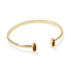 Looking for a pop of sparkle to add to your wrist stack? Meet the Emma Cuff Bracelet, aka your new style essential. Two elongated stones bookend this adjustable metal cuff you can fit to your wrist perfectly. On-trend and oh-so-cute, you'll style this bracelet time and time again. Designer, founder, and philanthropist Kendra Scott started her company in 2002, just three months after her first son was born. Her commitment to innovation, quality, customer service, and detail has taken her from a s Wrist Stacks, Gold Bangle Bracelet, Gold Bracelet Chain, Kendra Scott, Fashion Essentials, Tiger Eye, Bracelet Set, Chain Bracelet, Cuff Bracelet