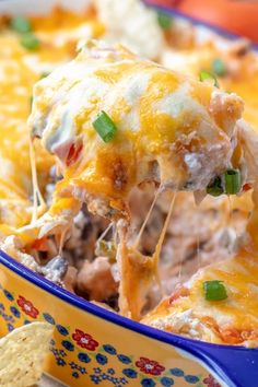 a casserole dish filled with meat and cheese, topped with tortilla chips