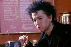 a man with black hair sitting at a table in front of a plate of food