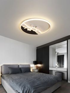 a large bed sitting under a round light in a bedroom