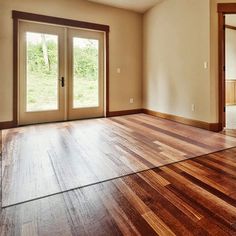 an empty room with wooden floors and sliding glass doors