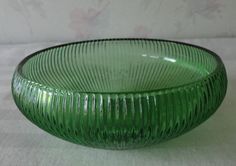 a green glass bowl sitting on top of a table