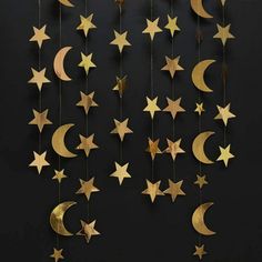 gold stars and crescents hanging from strings against a black background