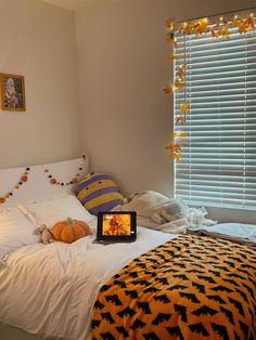 a bed room with a neatly made bed and a laptop on top of the bed