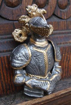 a metal figurine sitting on top of a wooden bench