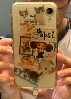 a person holding up a cell phone case with cats on it's sides and pictures