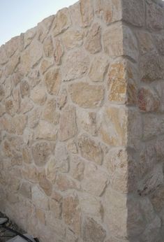 a large stone wall next to a building