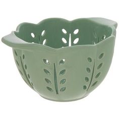 a green ceramic bowl with holes in the center and leaves on the side, set against a white background