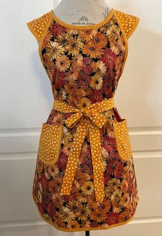 an apron on a mannequin with polka dots and sunflowers in yellow