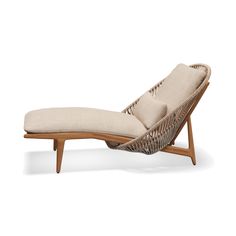 the chaise lounge chair is made out of wicker and has a beige cushion