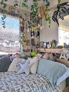 an unmade bed with many stuffed animals and plants hanging from it's ceiling