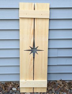 a wooden door with a metal star on the front and back side, sitting outside