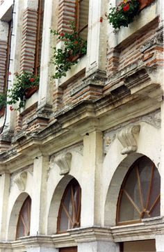 an old building with flowers on the windows