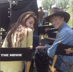 two people sitting in chairs with cowboy hats on